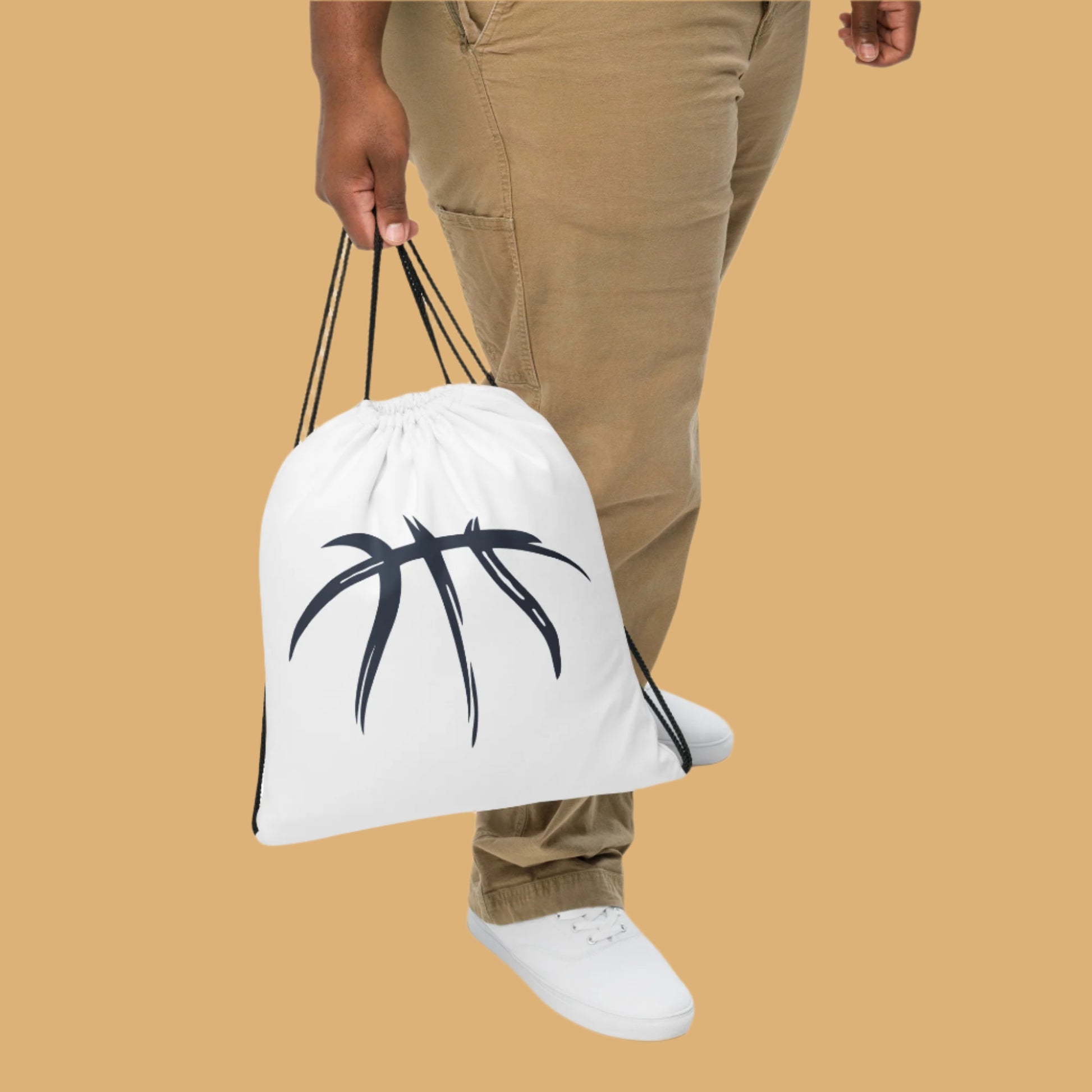 Person holding a white drawstring bag with a black logo on a white background