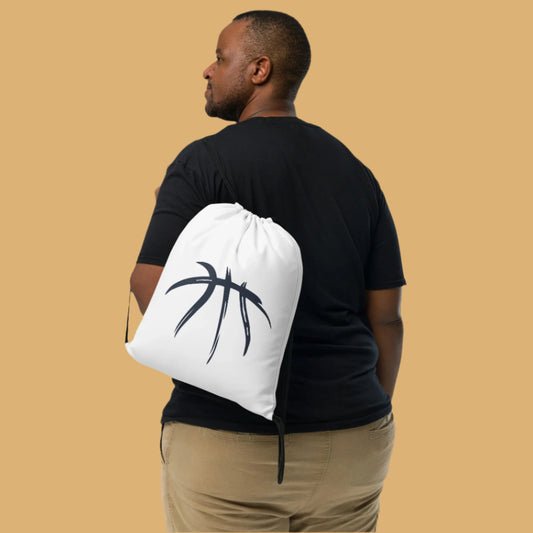 Man holding a white drawstring bag with a black logo against a beige background