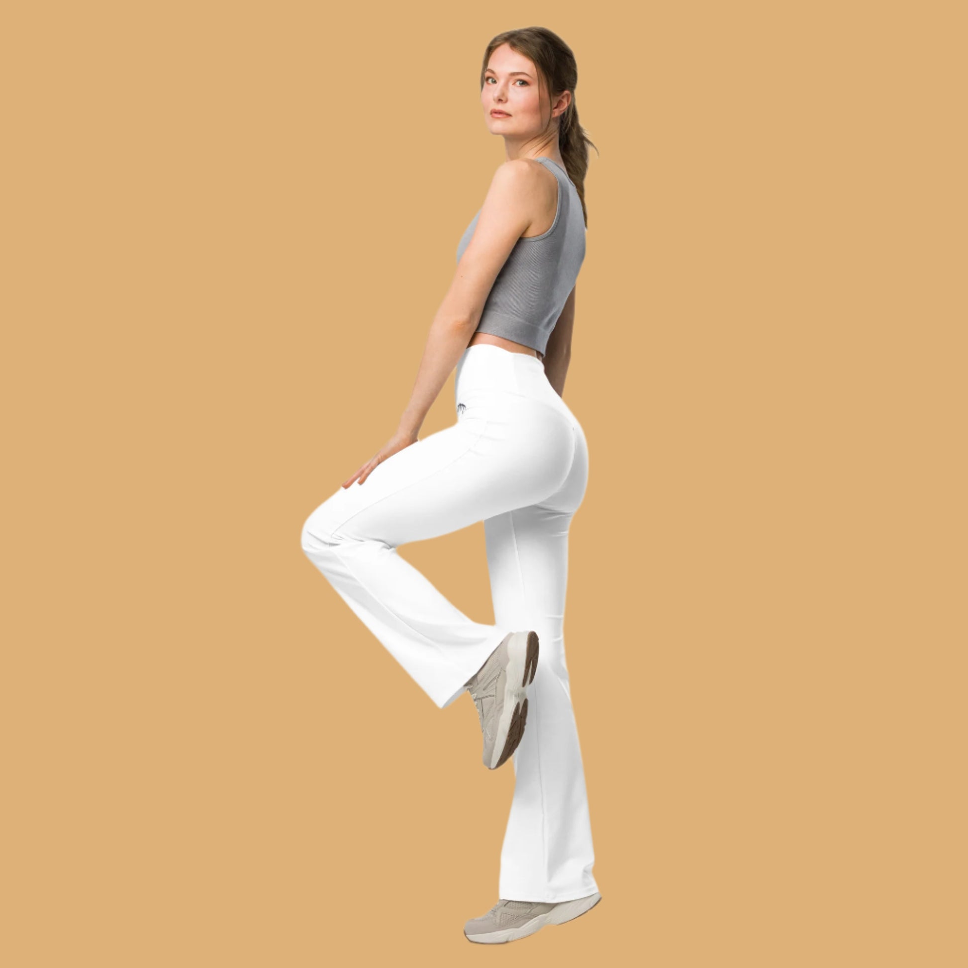 Woman wearing white pants and a gray top on a white background