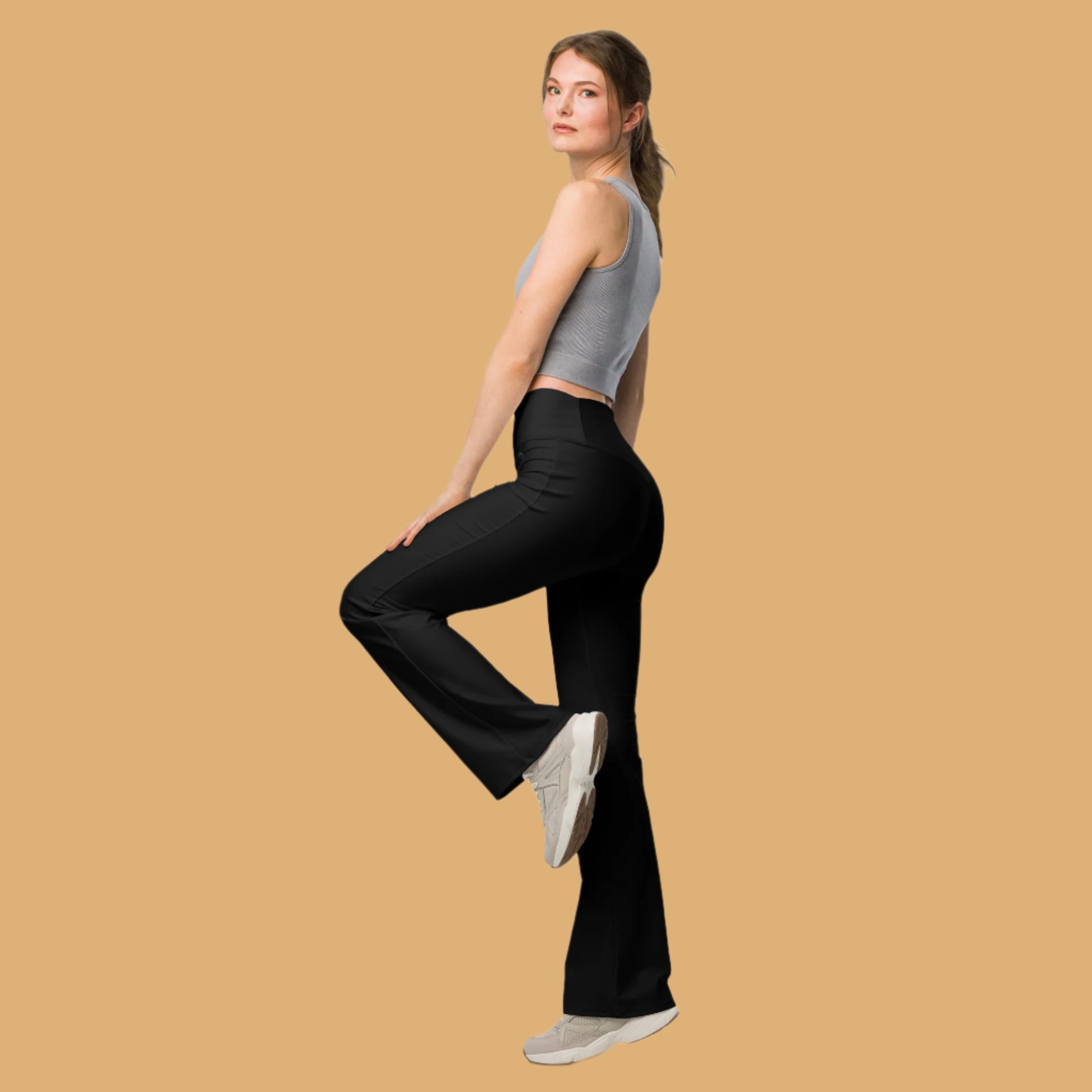 Woman wearing black pants and a gray top on a white background