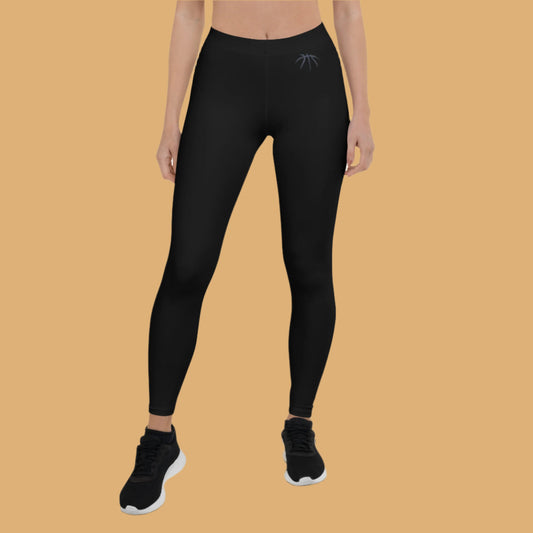 Person wearing black leggings with a logo on an orange background