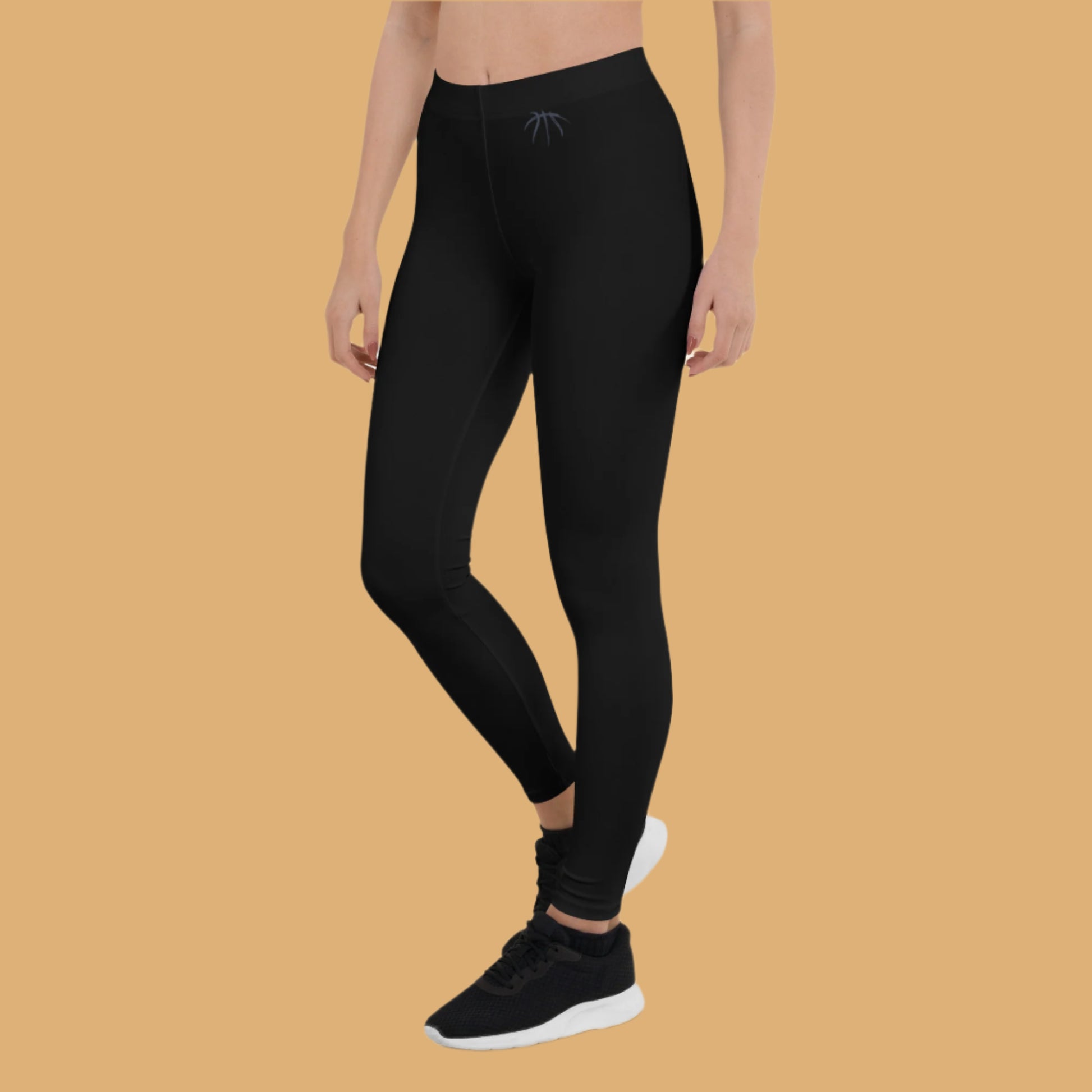Person wearing black leggings with a logo on a white background