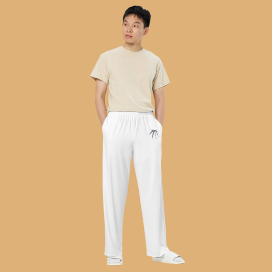 Person wearing a beige t-shirt and white pants with a small design on a white background