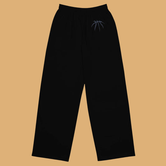 Black pants with a small logo on a beige background