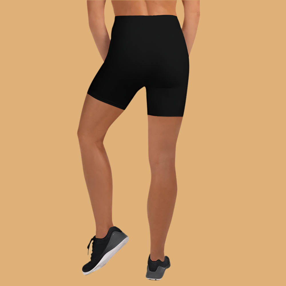 Person wearing black athletic shorts on a beige background