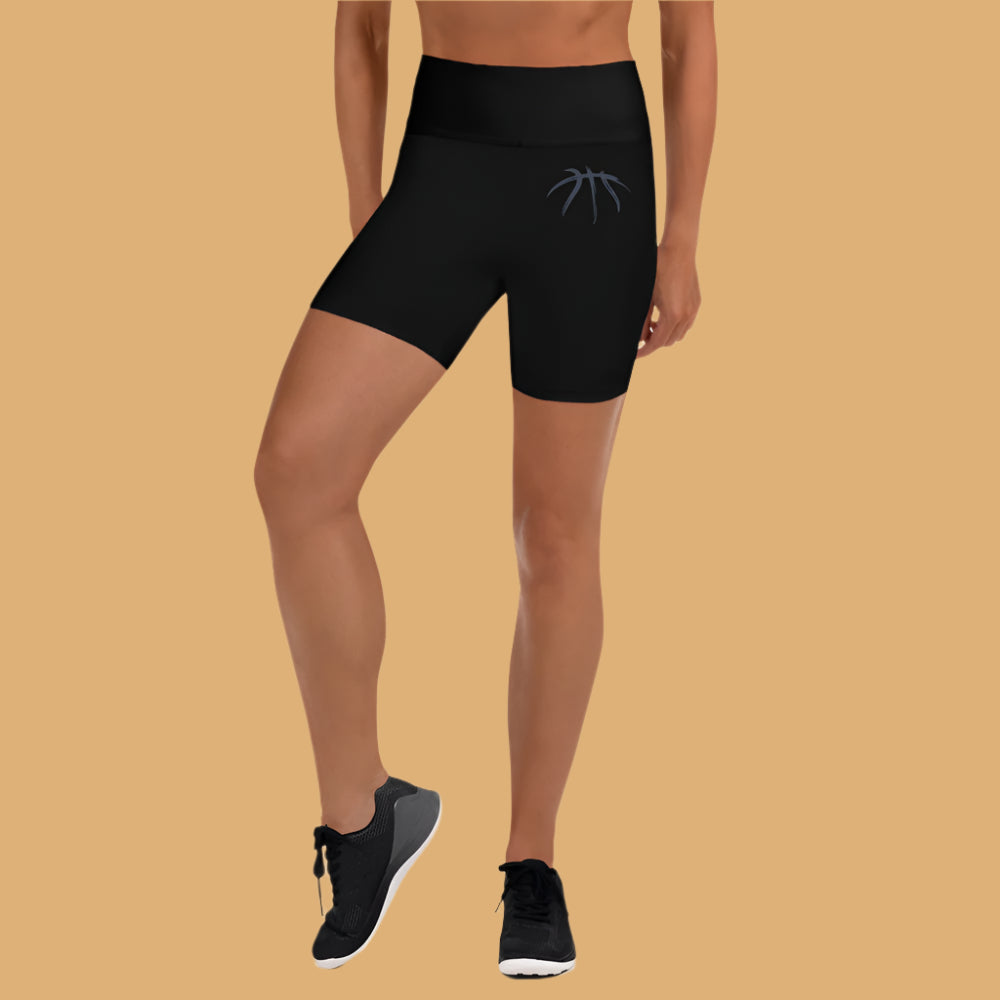 Person wearing black athletic shorts on a beige background