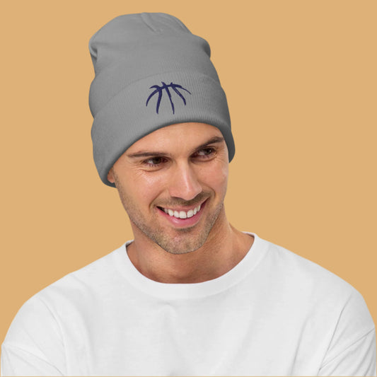 Man wearing a gray beanie with a logo on a beige background