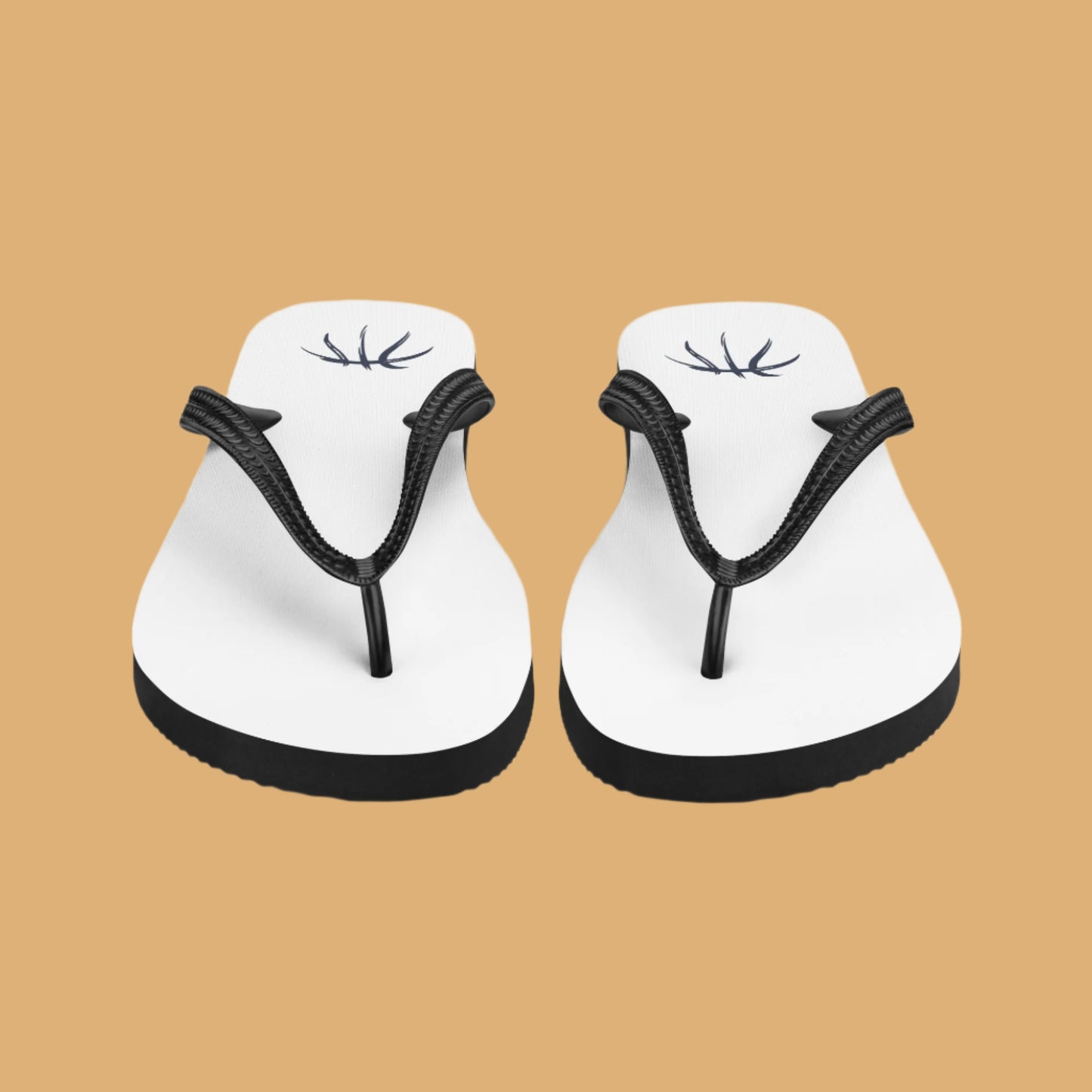 Pair of white flip-flops with black straps on a beige background