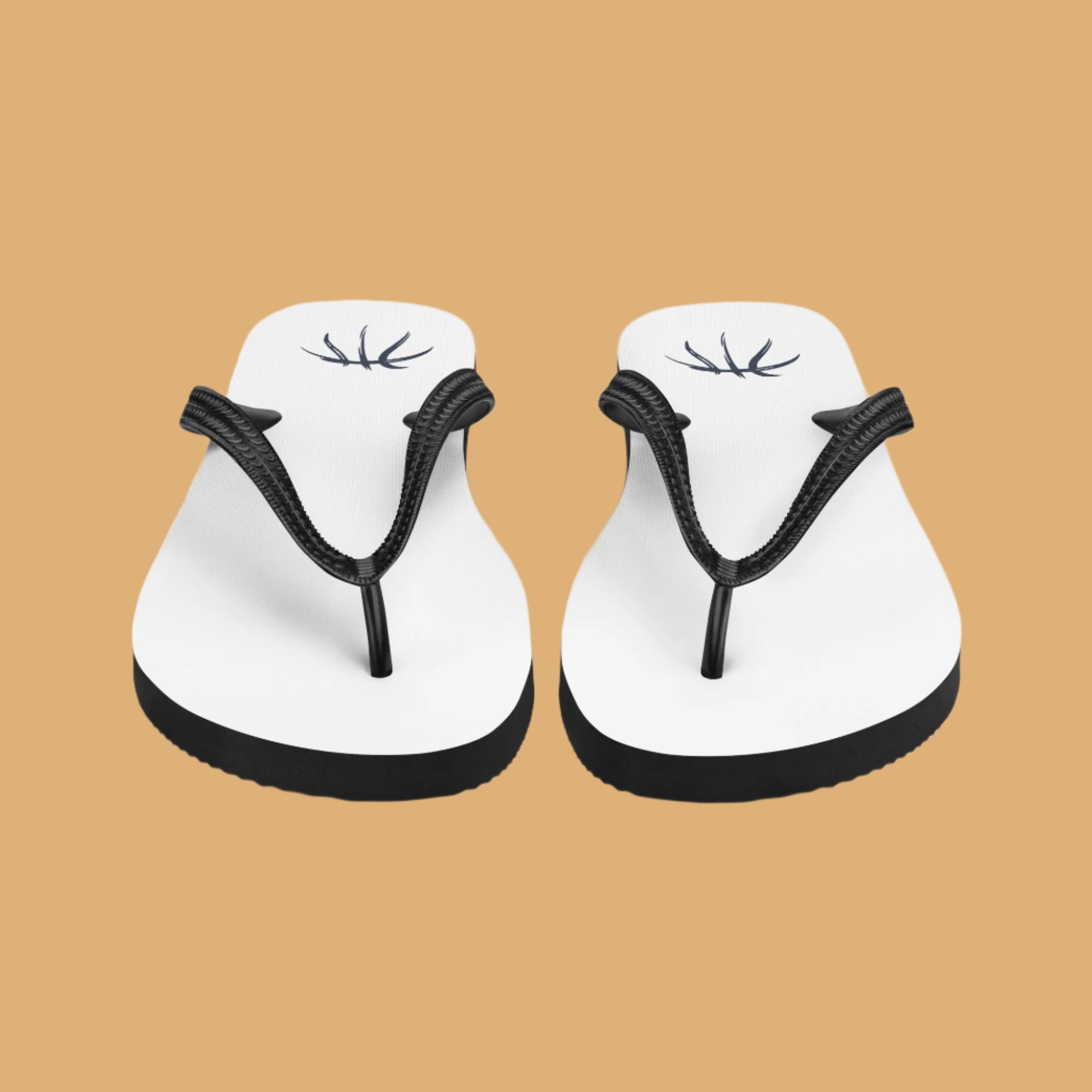 Pair of white flip-flops with black straps on a beige background