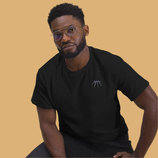 Man wearing a black t-shirt with a logo on a beige background