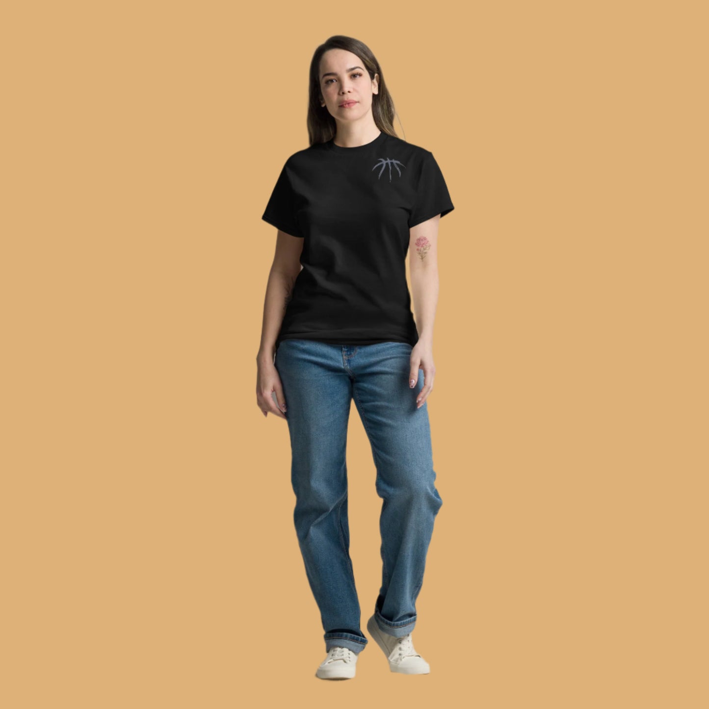 Person wearing a black t-shirt and blue jeans on a beige background