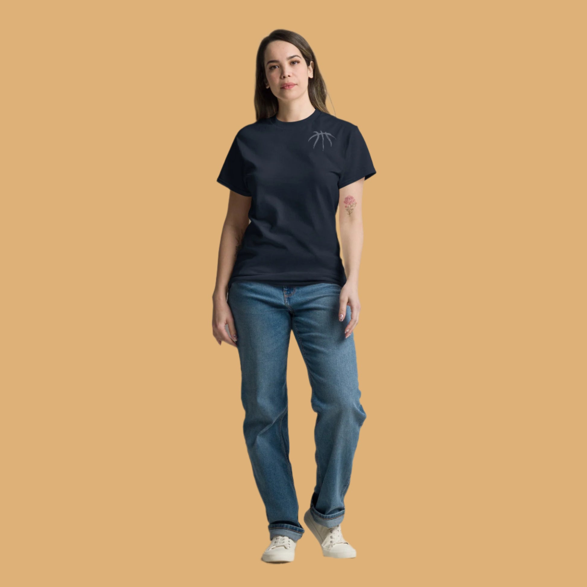 Person wearing a black t-shirt and blue jeans on a beige background