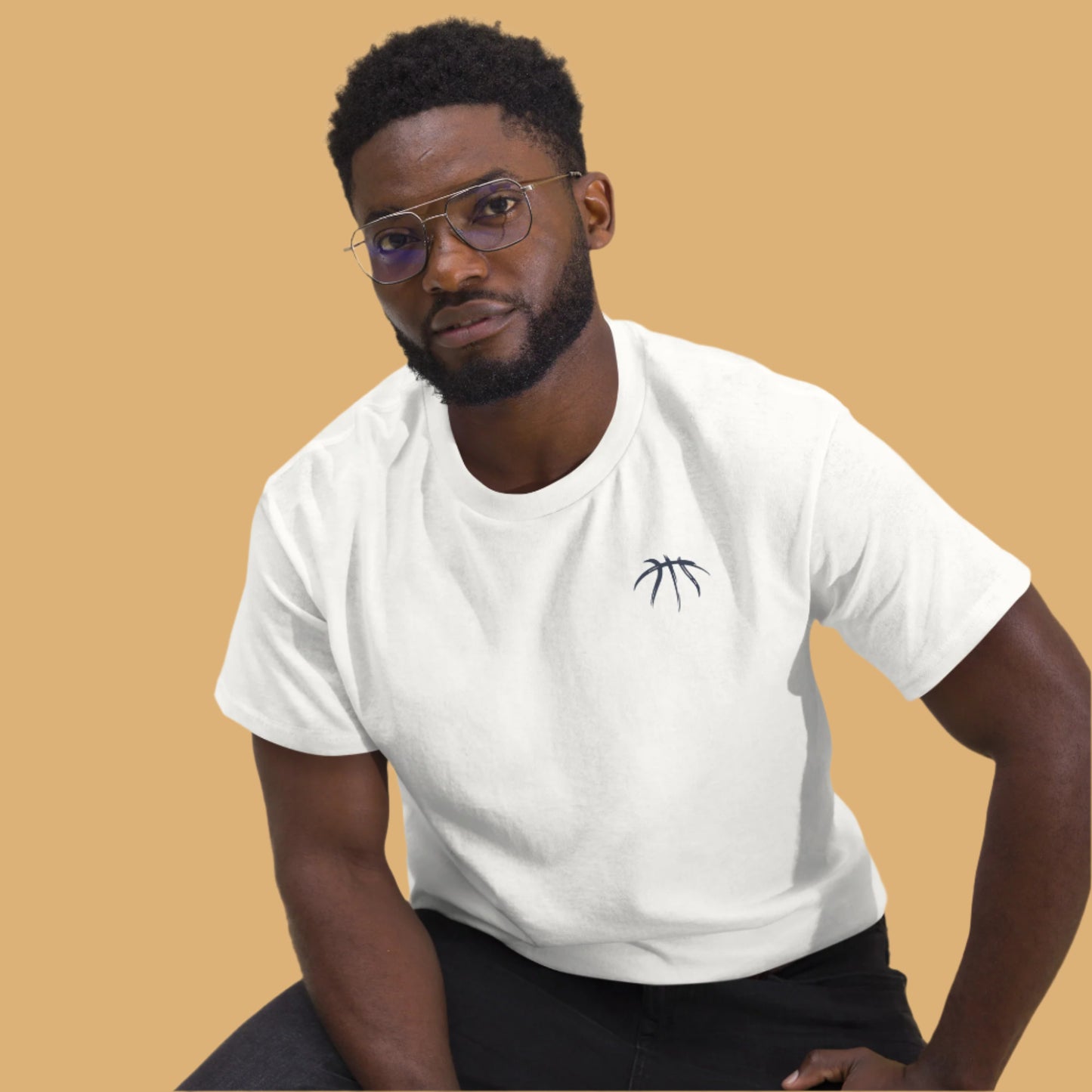 Man wearing a white t-shirt with a small logo on a beige background