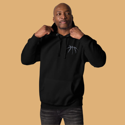 Man wearing a black hoodie with a logo on a beige background