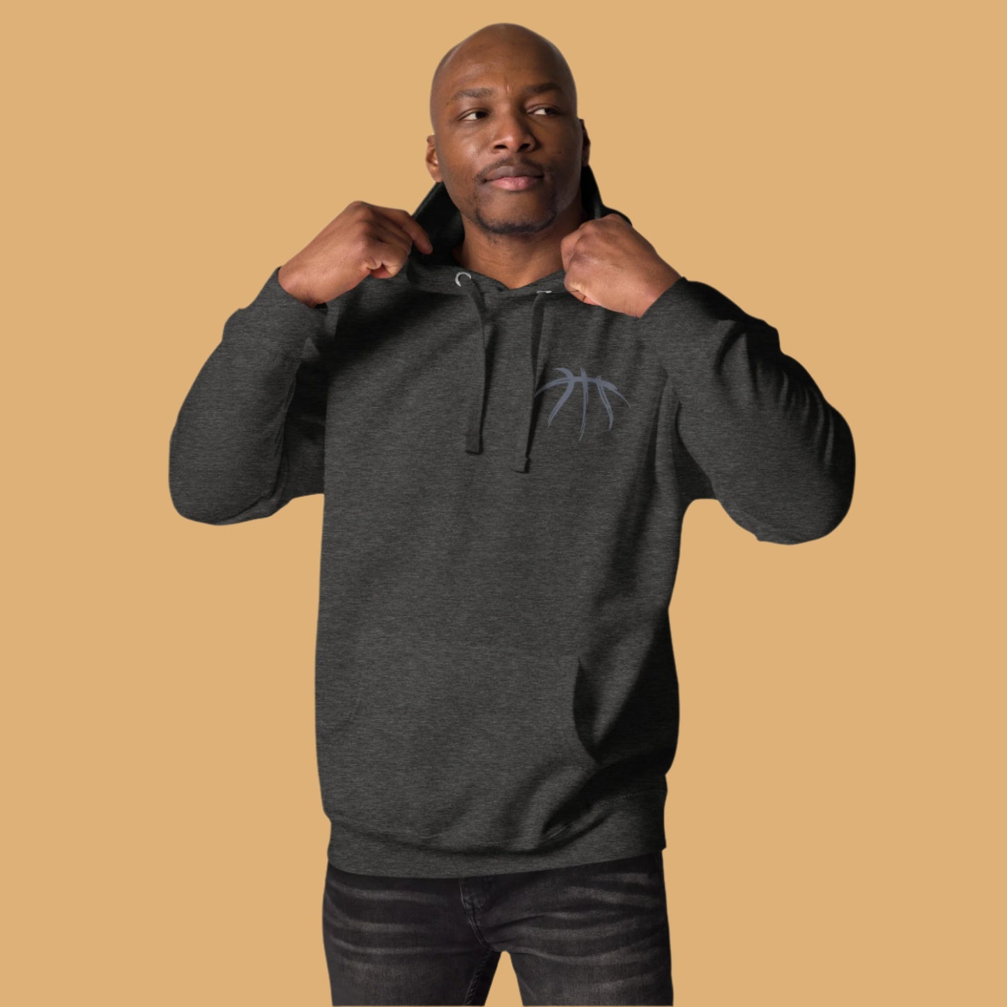 Man wearing a dark gray hoodie with a logo on a beige background