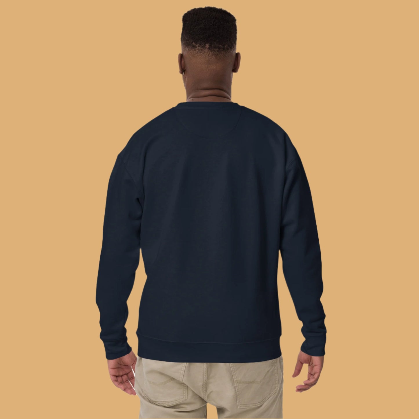 Person wearing a navy blue sweatshirt on a beige background