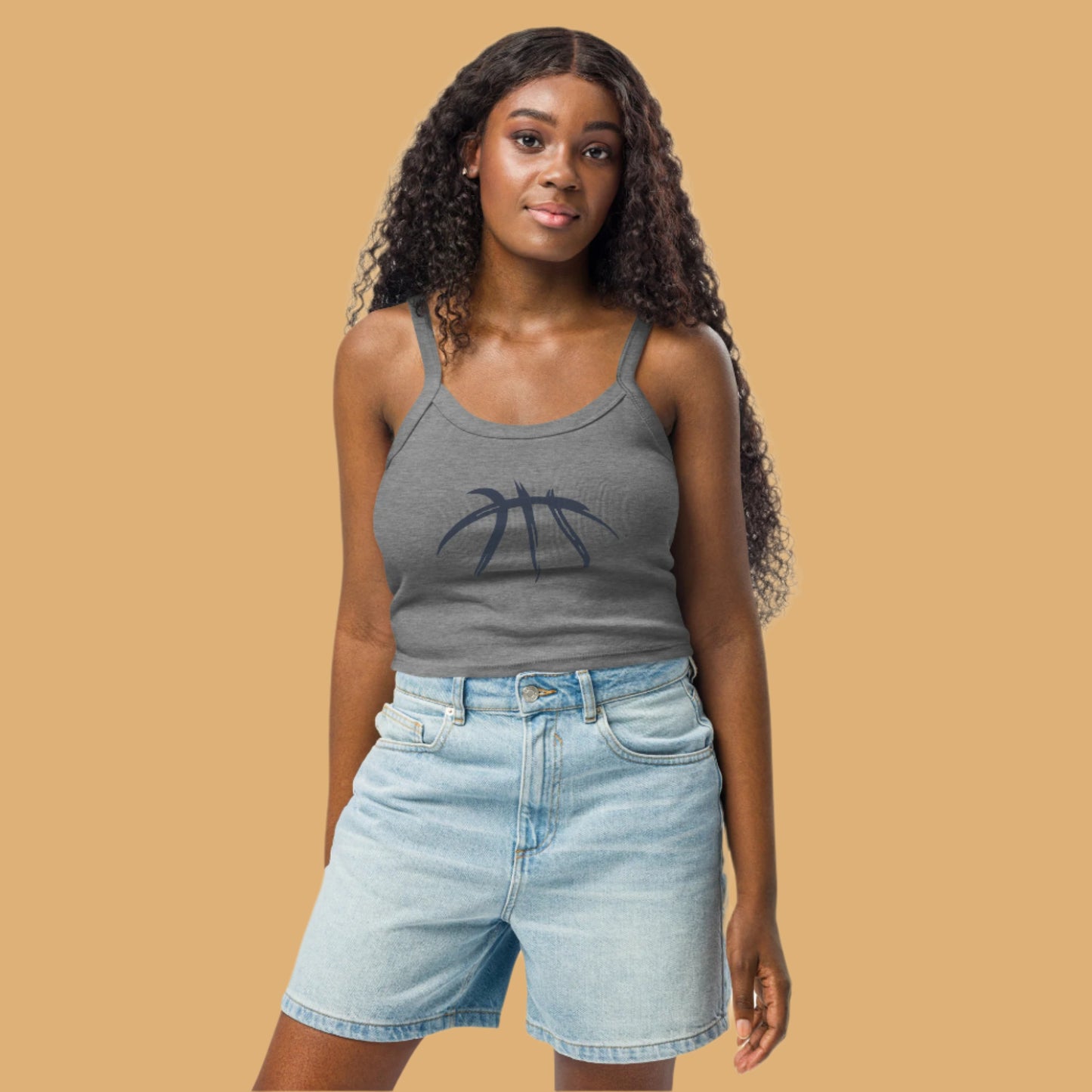 Woman wearing a gray tank top with a palm tree design and light blue denim shorts on a white background