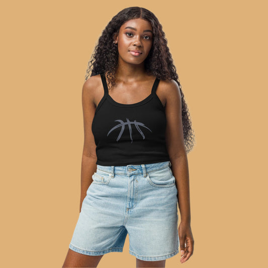 Woman wearing a black tank top with a graphic design and light blue denim shorts on a beige background
