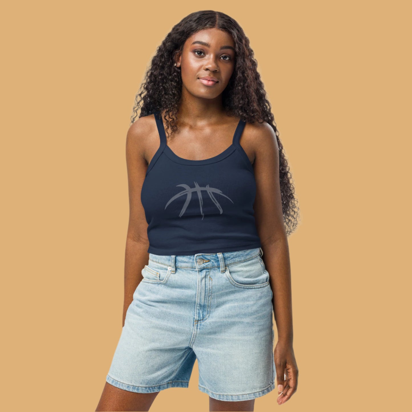 Woman wearing a navy tank top with a logo and light blue shorts on a white background
