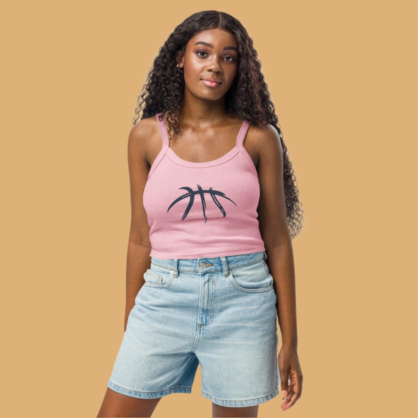 Woman wearing a pink tank top with a black graphic design on a beige background