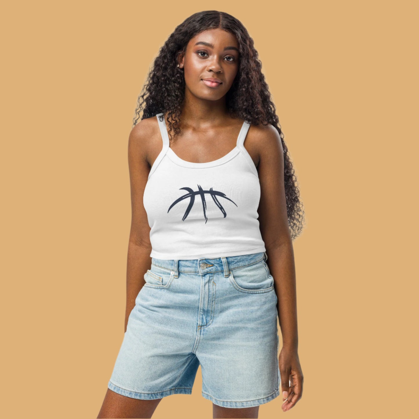 Woman wearing a white tank top with a black design and light blue denim shorts on a white background